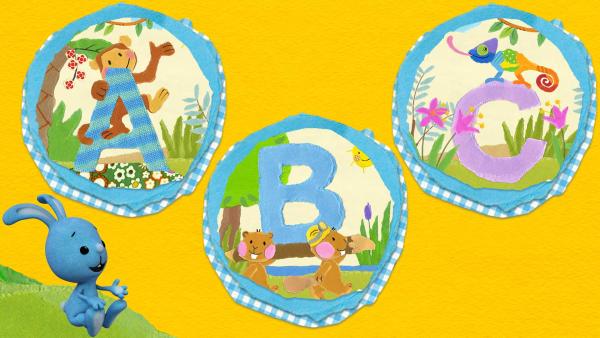 Kikaninchen sitzt auf einer grünen Wiese und schaut sich Buchstaben an. Der Affe klettert um den Großbuchstaben A, zwei Biber tragen ein "B" und ein buntes Chamäleon sitzt auf dem Buchstaben C. | Rechte: KiKA