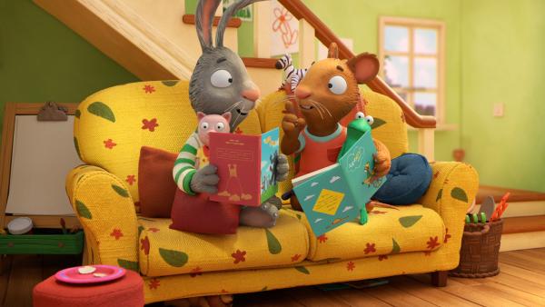 Pip und Posy sitzen auf dem Sofa und schauen sich gemeinsam Bücher an.  | Rechte: ZDF